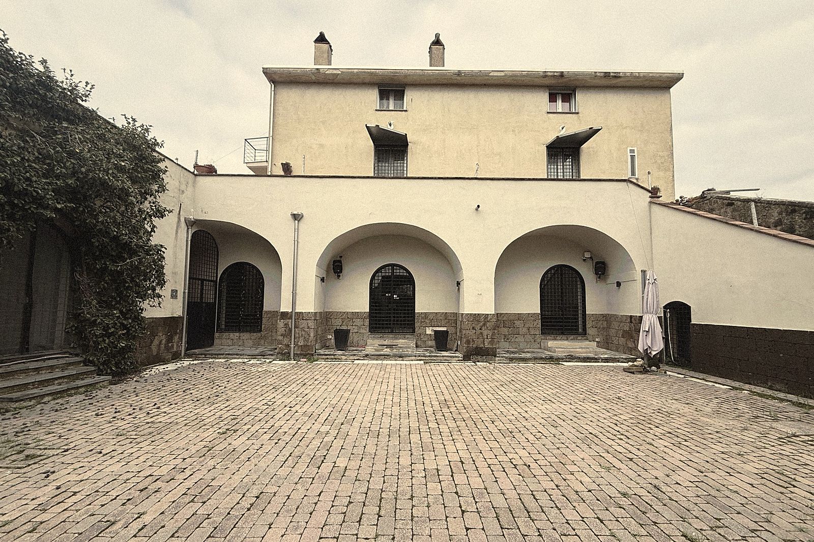 Il cortile e la facciata della dimora all'imbrunire