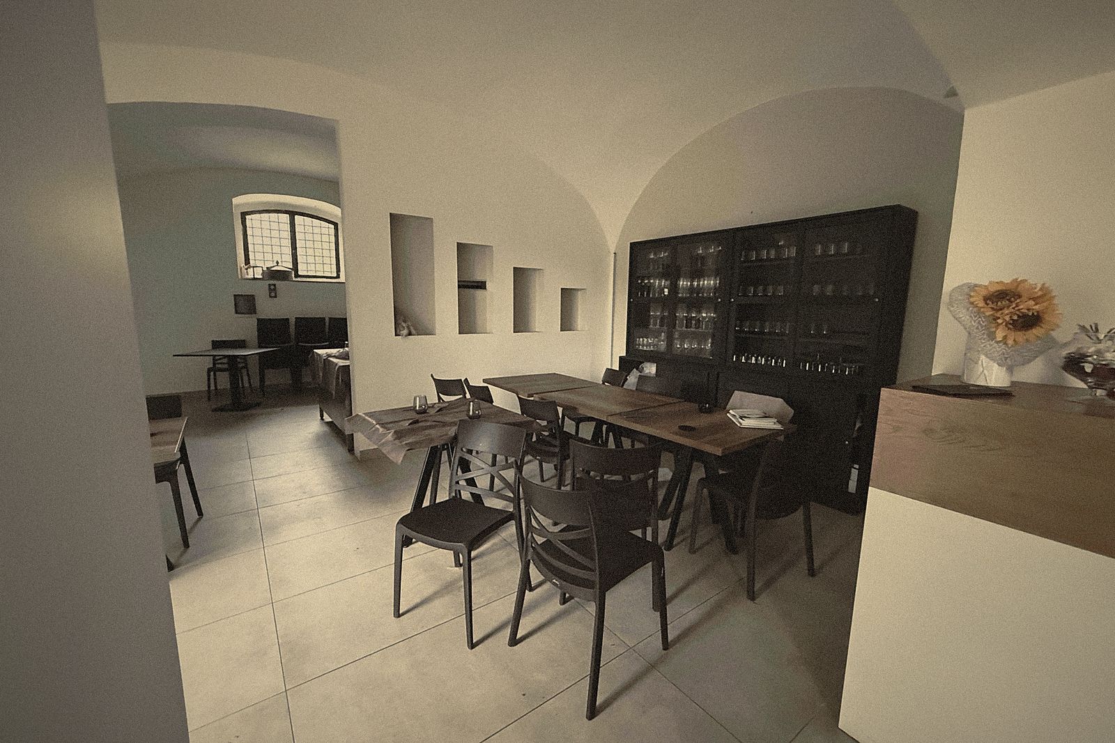 La sala con le volte antiche, le nicchie scavate nel muro e una tavola lunga pronta